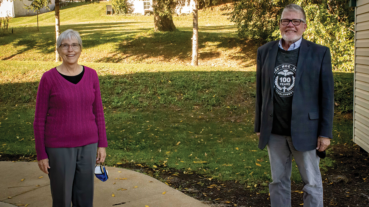 Incoming executive director Ann Graber Hershberger and outgoing executive director J Ron Byler strike a socially distant pose at the MCC U.S. office in Akron, Pa., on Oct. 17 during a virtual board meeting and livestreamed national event commemorating MCC’s centennial year. — Frederick Yocum/MCC