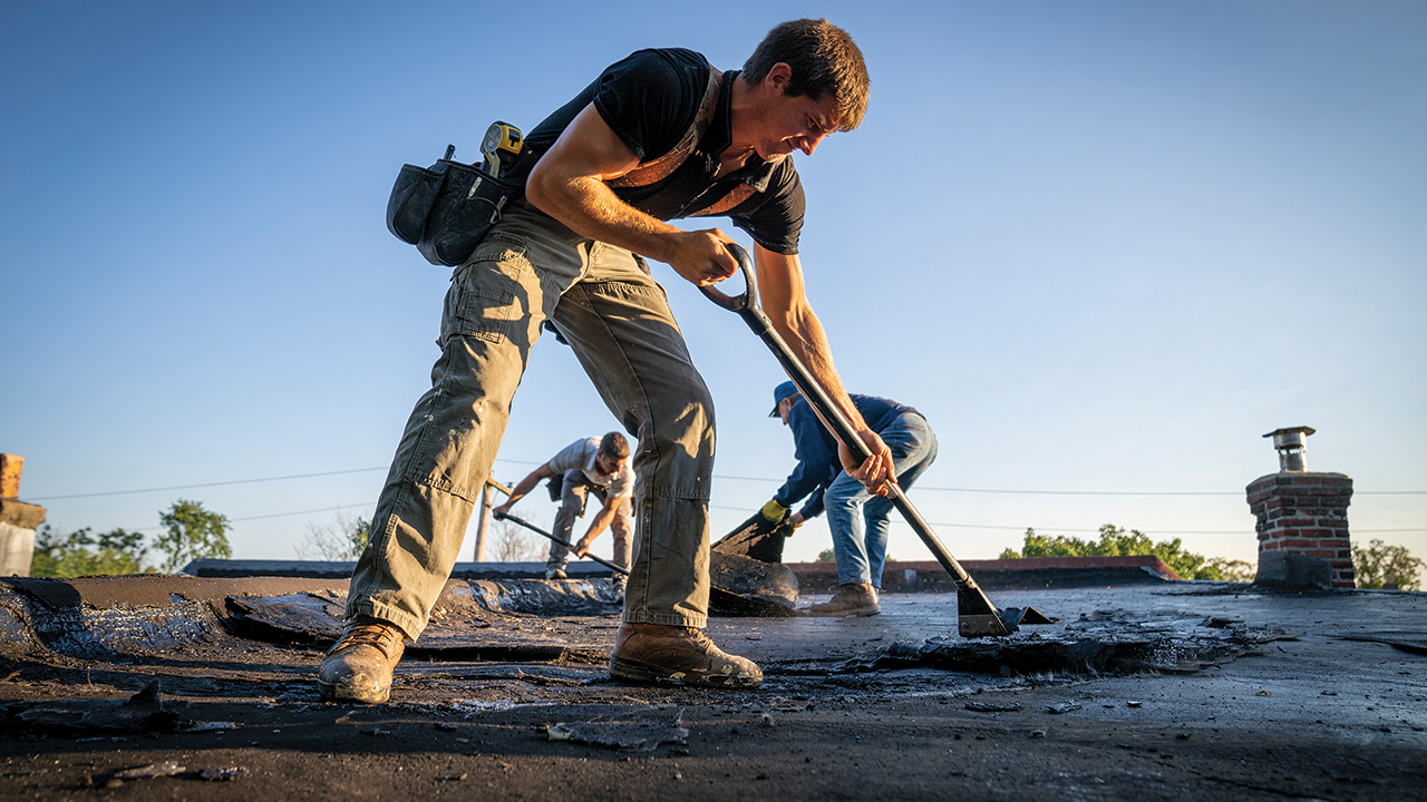 Calvin Zimmerman removes the old roof of LaTanya Wade’s house in Darby, Pa., with fellow Mennonite Disaster Service volunteers Harold Zimmerman and Frank Hoover. — Mennonite Disaster Service