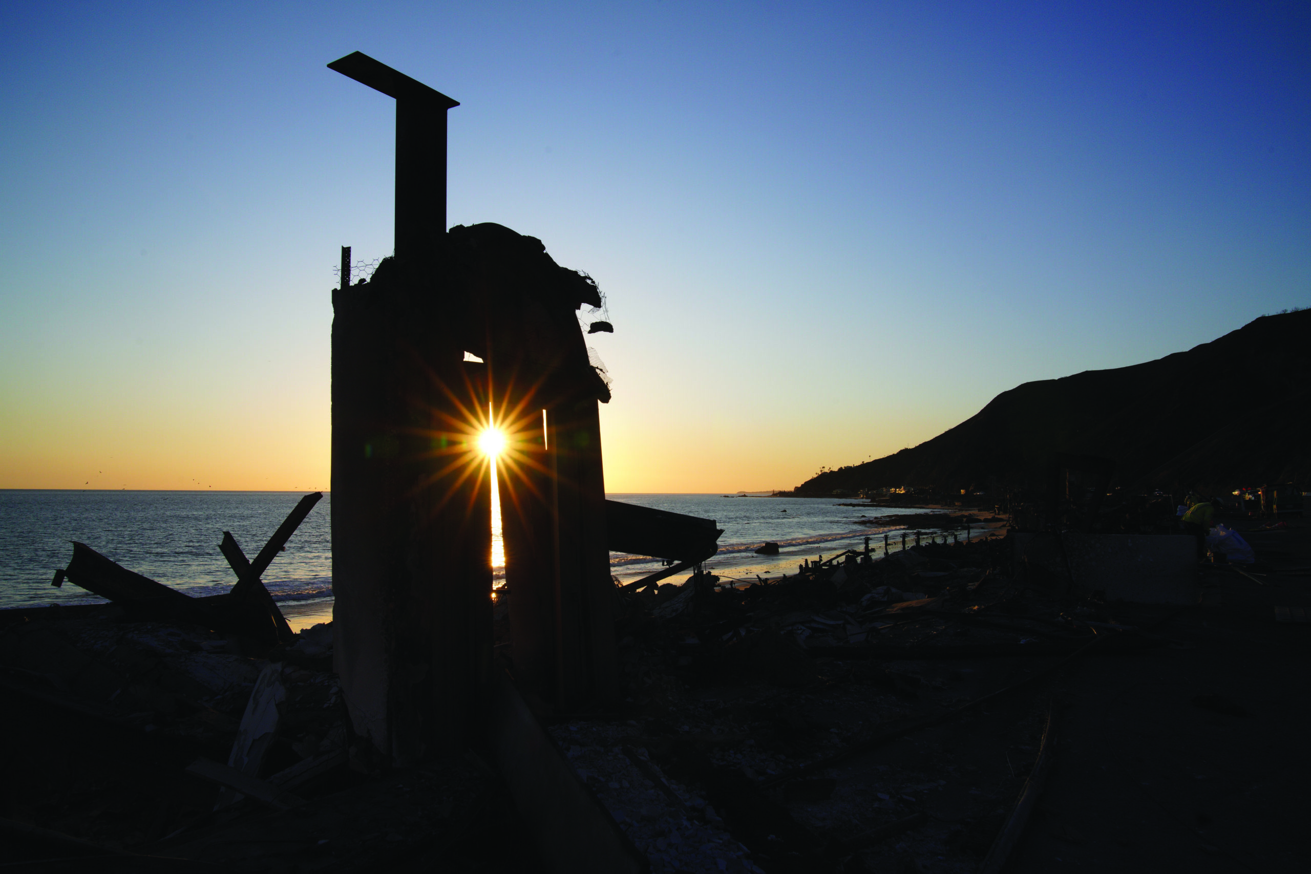 The setting sun shines through what remains of a doorway of a destroyed home from the Palisades Fire along the Pacific Coast Highway in Malibu, Calif., Wednesday. Jan. 15, 2025. (AP Photo/Richard Vogel)