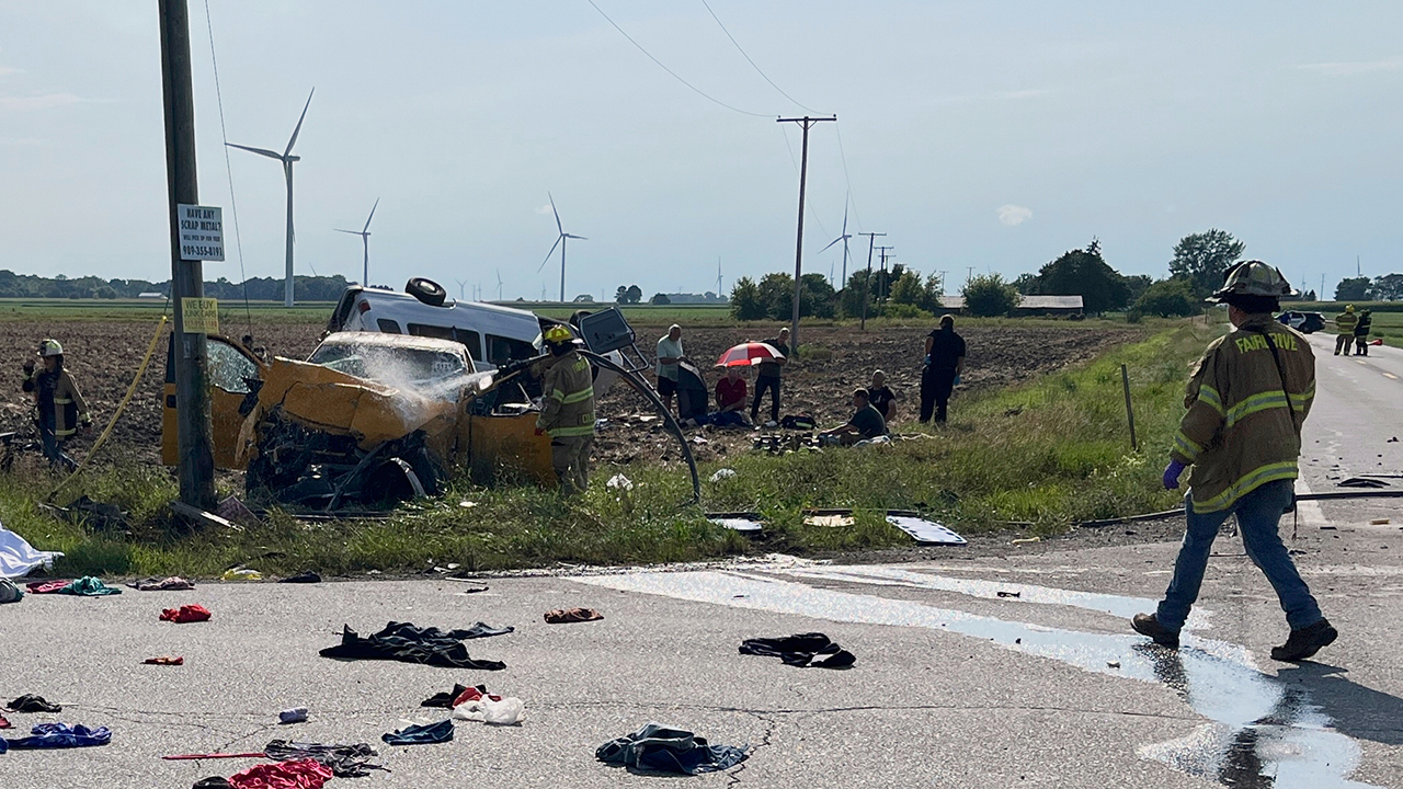 A firefighter sprays a pickup truck after a deadly two-vehicle crash Aug. 12 in Tuscola County, Mich. — WJRT-TV via AP