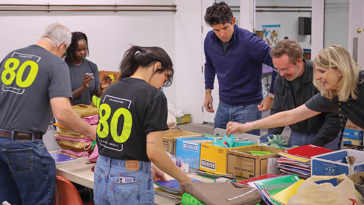 Members of the Everence Praxis team volunteer with Mennonite Central Committee in Goshen, Ind., packing school kits for children affected by disaster or conflict around the world. — Everence