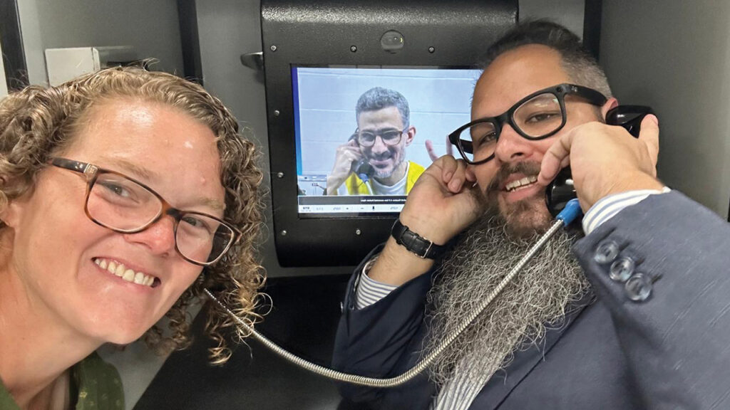 Former Cincinnati Children’s Hospital chaplain Adam Allen, right, talks with Ayman Soliman by videophone at a detention facility. They are joined by Lizzy Diop, whose job was terminated by the hospital for supporting Soliman in a television interview. — Adam Allen