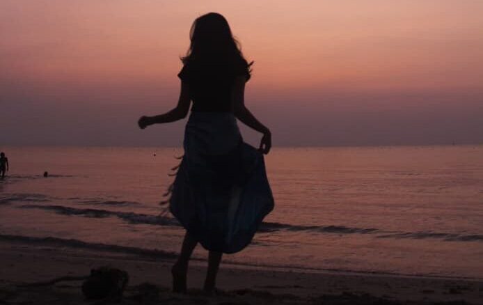 Figure standing before sunset.