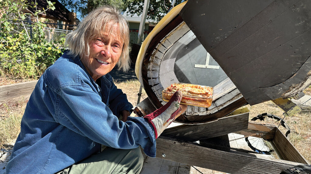 Mary Sprunger-Froese removes a lasagna from the solar oven. — Donna Johnson