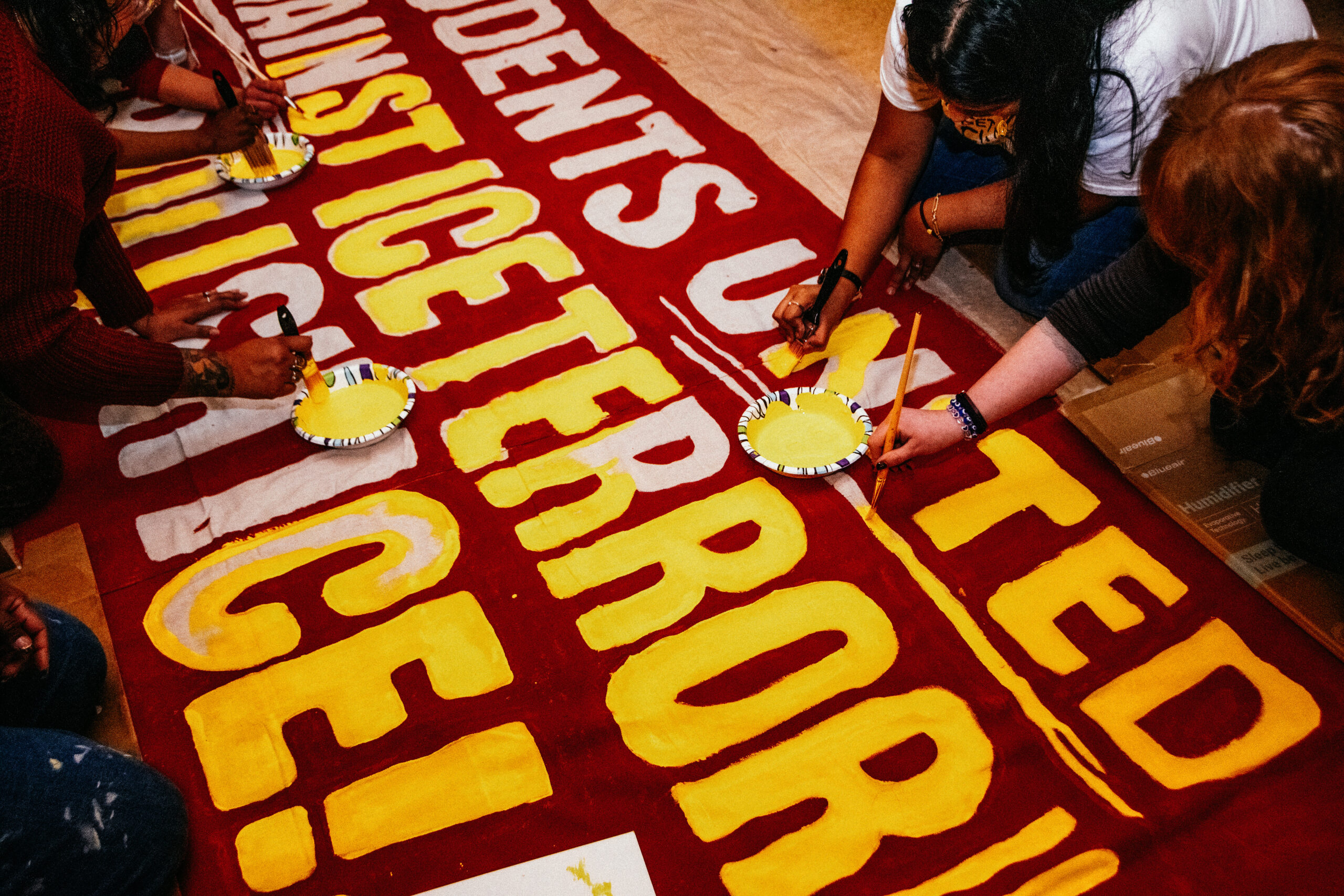 Students paint signs during an art build before a Jan. 23 protest in Minneapolis. — Juan Moya/AW